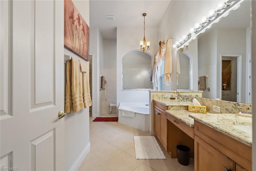 5757 Mango Circle Naples, FL 34110 - Photo 19 of 38 a spacious bathroom with a granite countertop tub sink and mirror