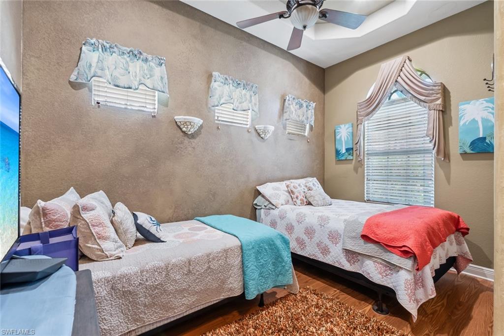 5757 Mango Circle Naples, FL 34110 - Photo 23 of 38 a bedroom with two beds and a chandelier