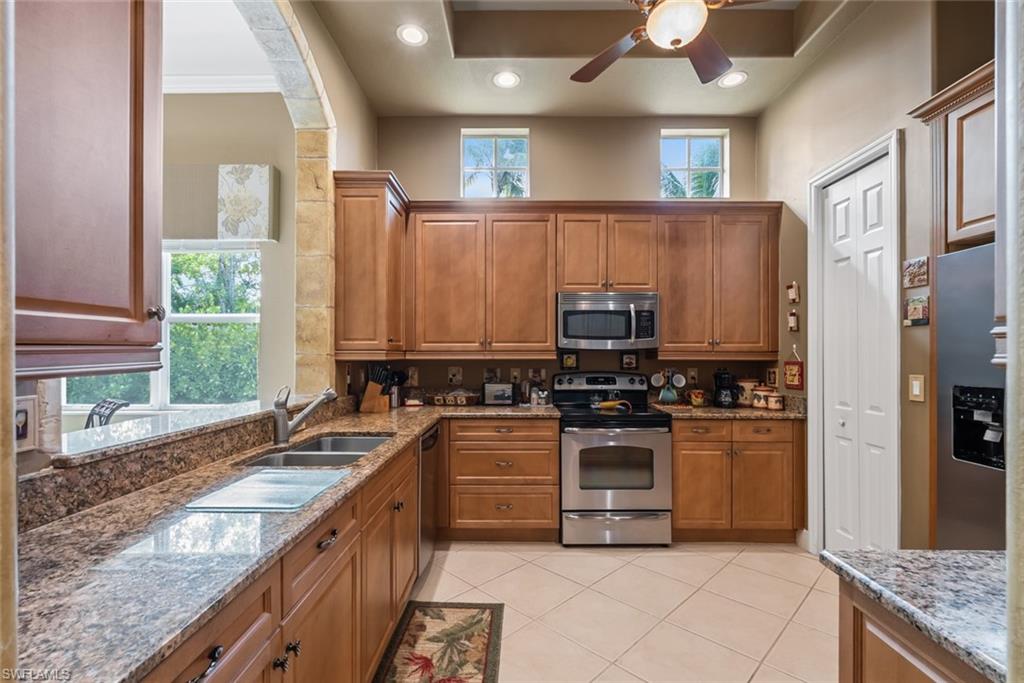 5757 Mango Circle Naples, FL 34110 - Photo 3 of 38 a kitchen with stainless steel appliances granite countertop a stove a sink and a refrigerator