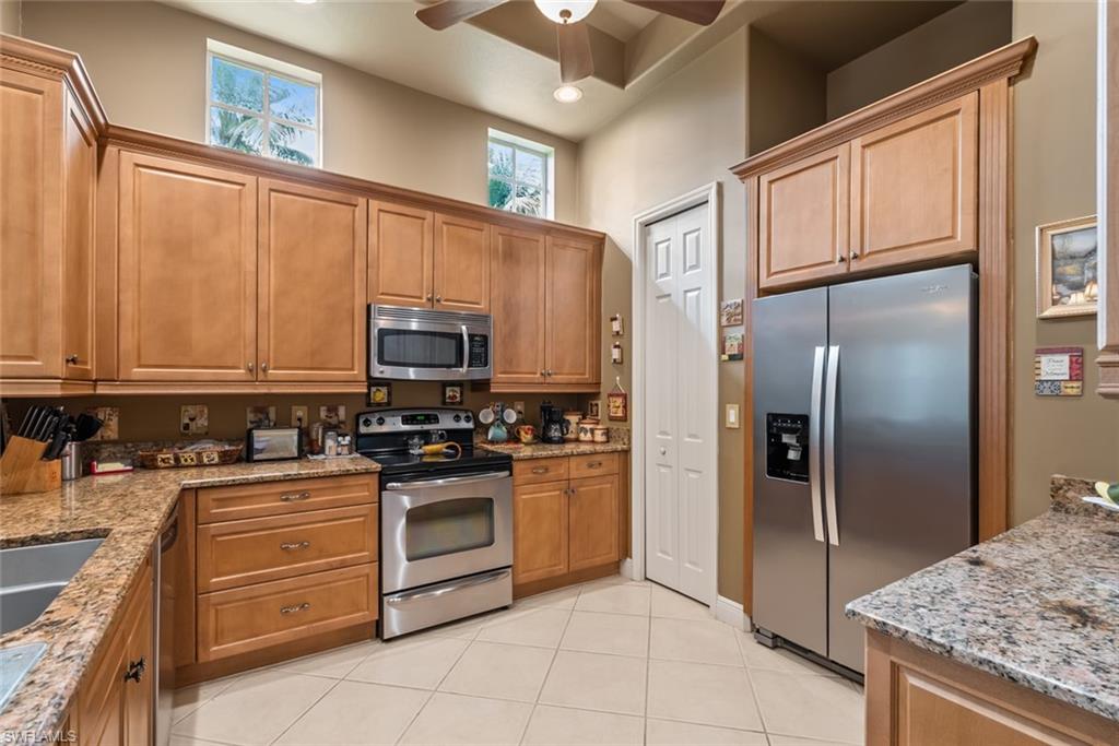 5757 Mango Circle Naples, FL 34110 - Photo 5 of 38 a kitchen with stainless steel appliances granite countertop a refrigerator stove and sink