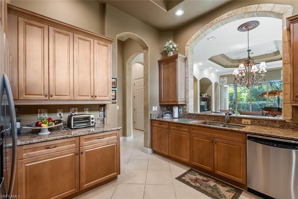 5757 Mango Circle Naples, FL 34110 - Photo 7 of 38 a kitchen with stainless steel appliances granite countertop a sink and cabinets
