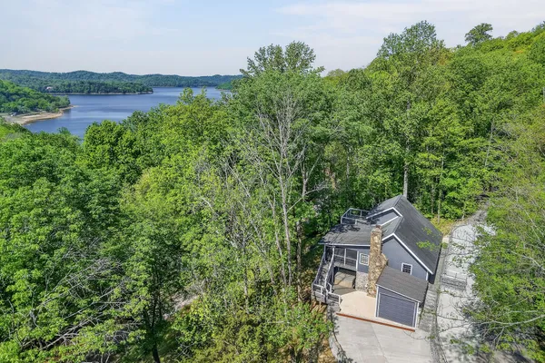 an aerial view of a house with a yard and lake view