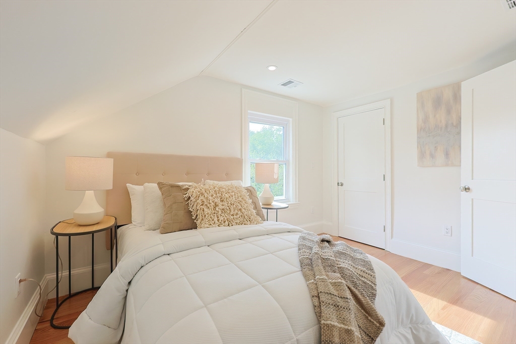 179 B Main Street, Unit B Medford, MA 02155 - Photo 17 of 40 a bed room with a bed and a lamp