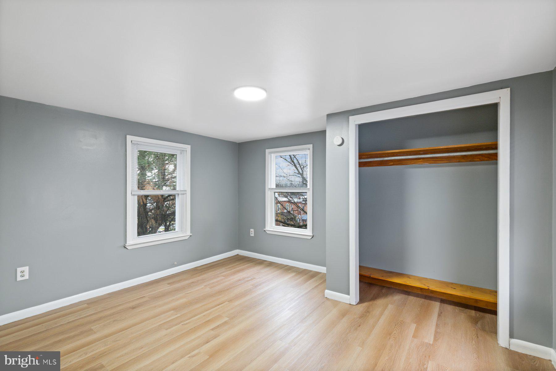 3700 7th Street Baltimore, MD 21225 - Photo 11 of 25 an empty room with wooden floor and windows