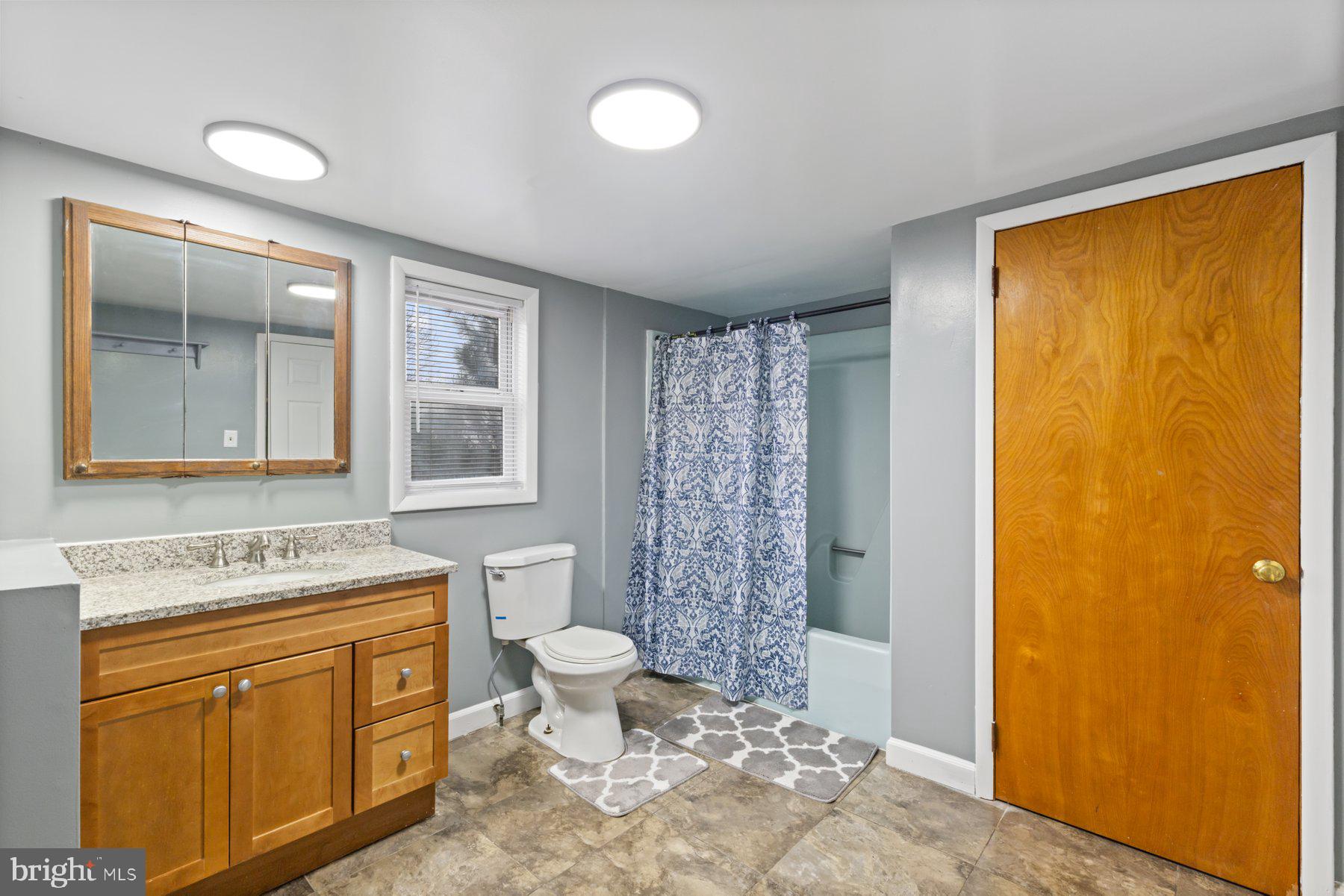 3700 7th Street Baltimore, MD 21225 - Photo 13 of 25 a bathroom with a granite countertop toilet sink and mirror