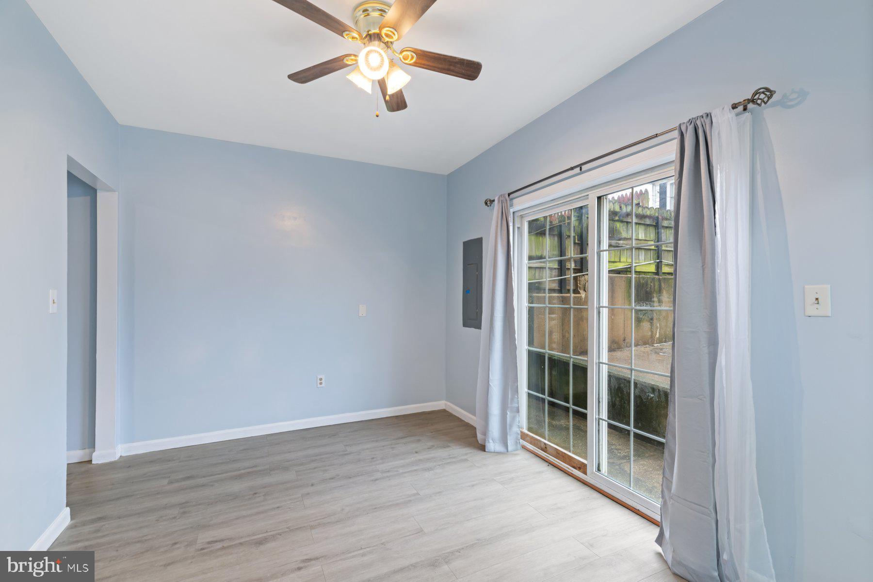 3700 7th Street Baltimore, MD 21225 - Photo 4 of 25 an empty room with wooden floor fan and windows