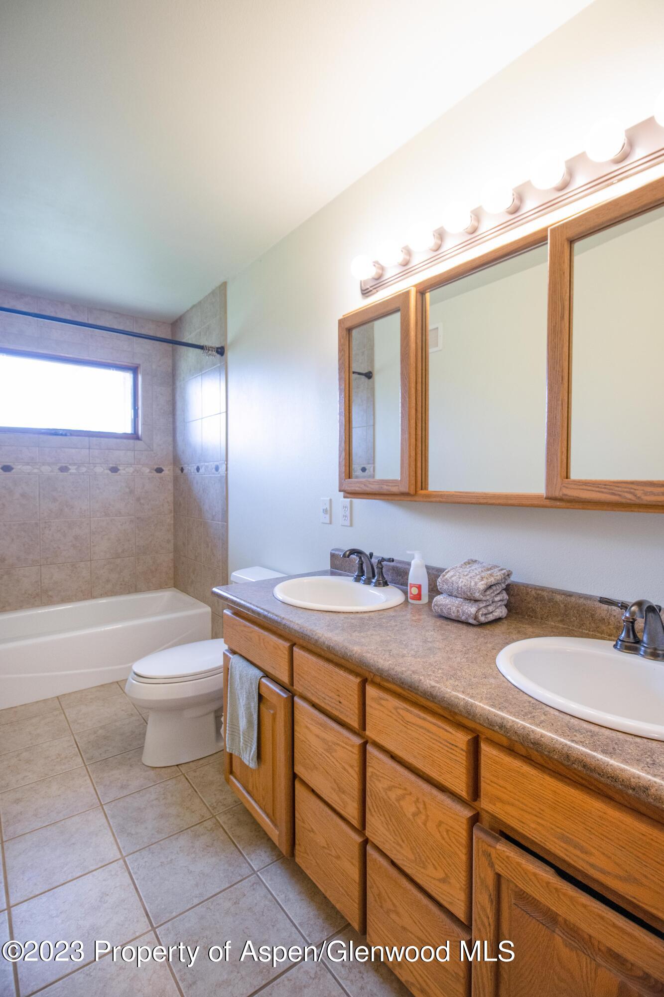1840 County Road 293 Rifle, CO 81650 - Photo 21 of 27 a bathroom with a granite countertop sink a toilet a mirror and bathtub