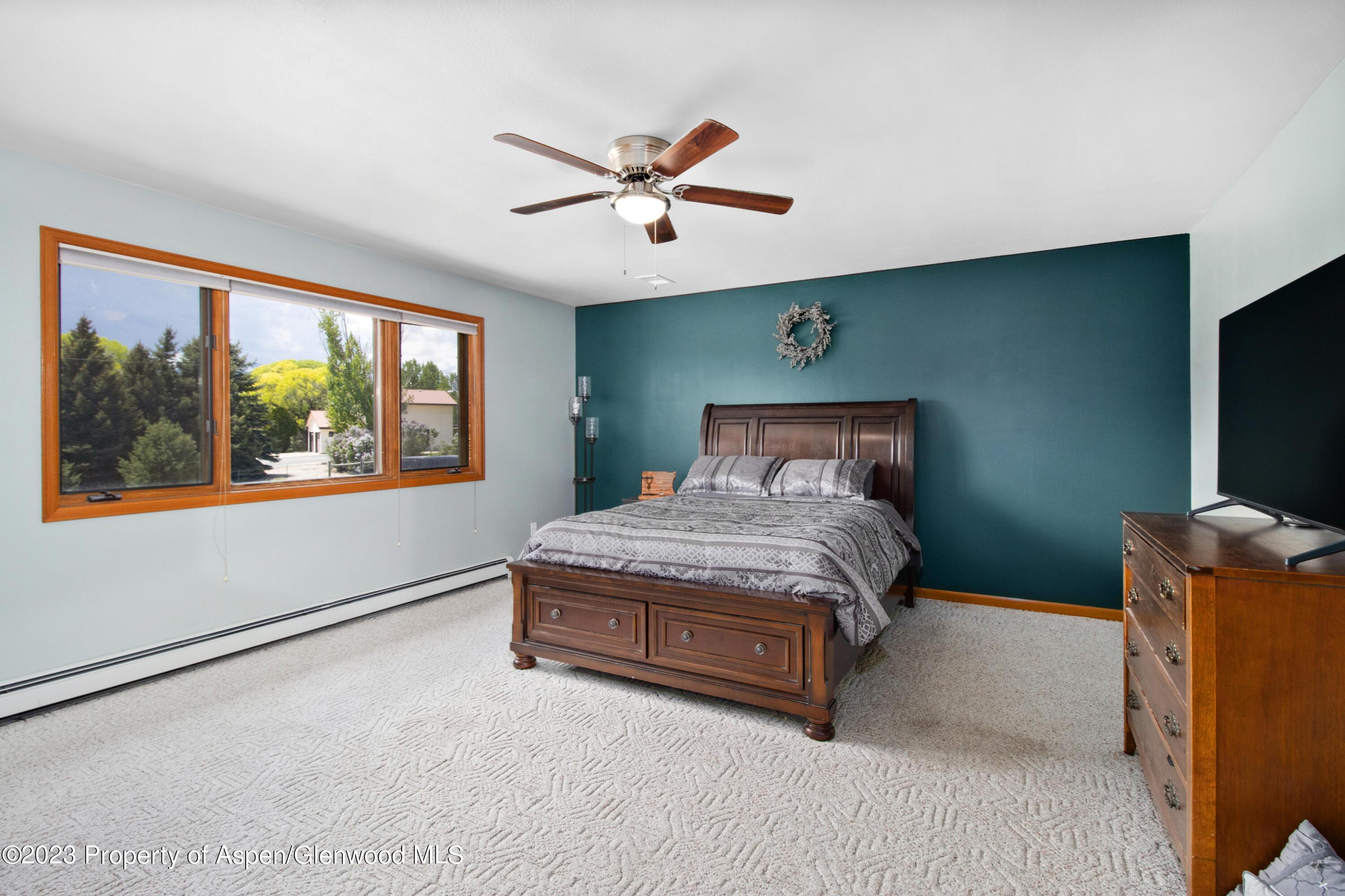 1840 County Road 293 Rifle, CO 81650 - Photo 24 of 27 a bedroom with a large bed and a flat tv screen on dresser