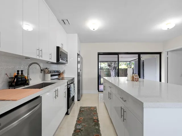 a kitchen with stainless steel appliances a sink stove and cabinets