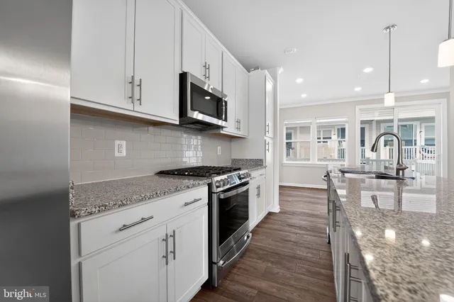 a view of kitchen with refrigerator microwave and wooden floor