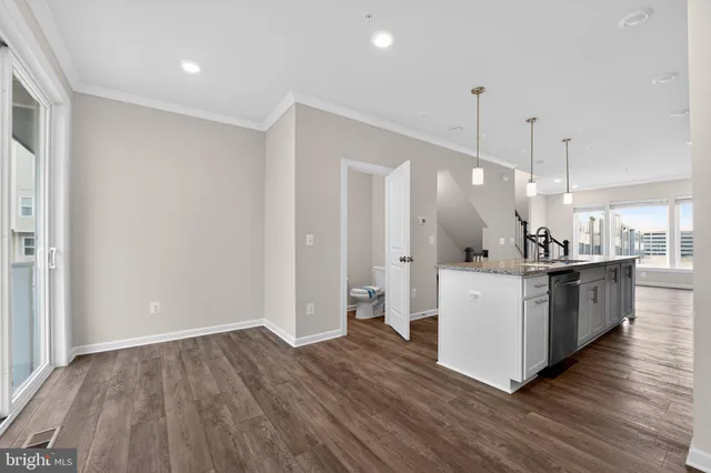 a kitchen with stainless steel appliances kitchen island granite countertop a refrigerator a stove a sink dishwasher and a refrigerator with wooden floor