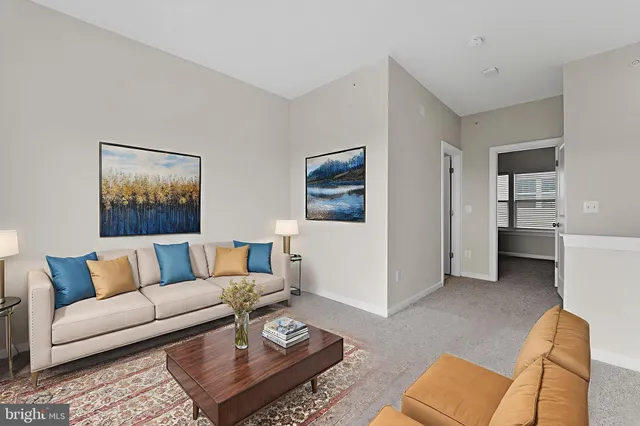 a living room with furniture and view of kitchen
