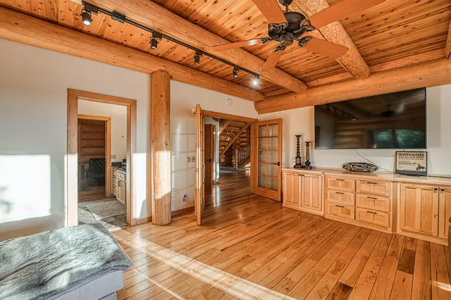 a bedroom with a bed and wooden floor