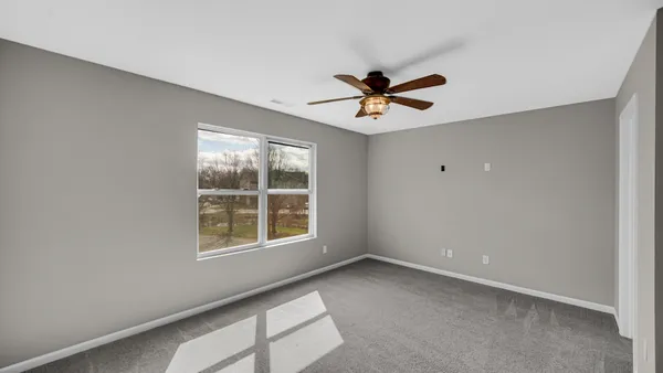 a view of a big room with wooden floor and windows
