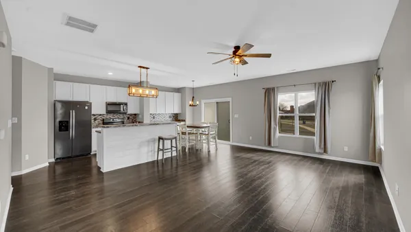 a view of kitchen with stainless steel appliances refrigerator stove microwave and cabinets