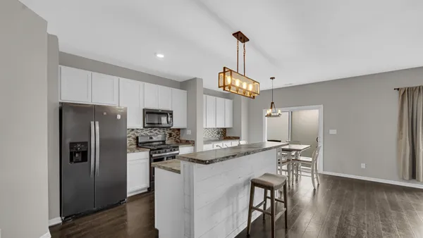 a kitchen with stainless steel appliances granite countertop a refrigerator a stove a sink and a refrigerator