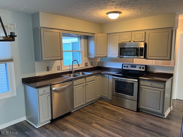 2276 Raber Road, Unit C Uniontown, OH 44685 - Photo 4 of 13 Kitchen with appliances with stainless steel finishes, a textured ceiling, dark wood-type flooring, decorative backsplash, and dark stone counters