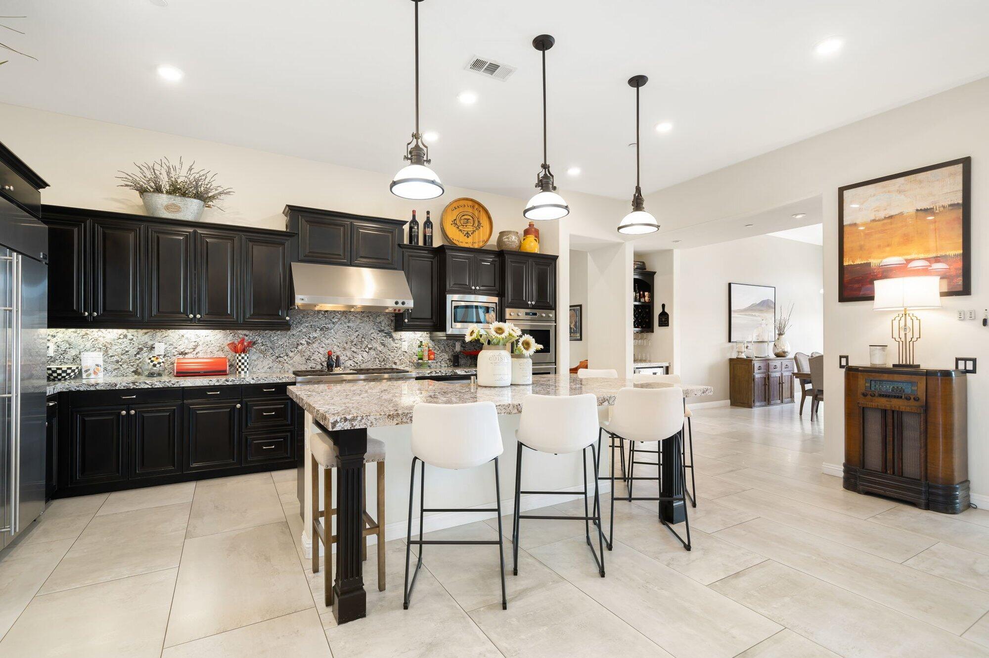 81675 Macbeth Street La Quinta, CA 92253 - Photo 21 of 76 a kitchen with stainless steel appliances granite countertop a sink a stove and a wooden floors