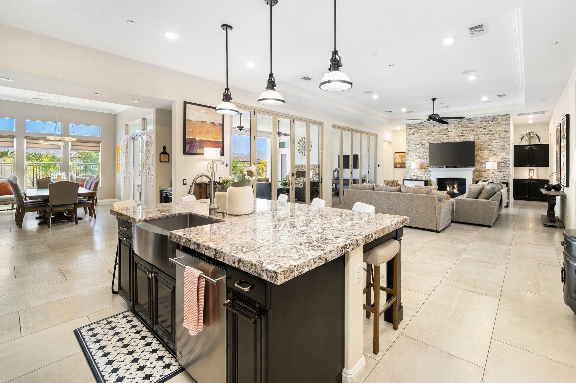 81675 Macbeth Street La Quinta, CA 92253 - Photo 25 of 76 a open kitchen with stainless steel appliances granite countertop a stove top oven a sink dishwasher a dining table and chairs with wooden floor
