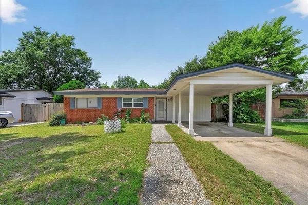 a front view of a house with a yard and trees