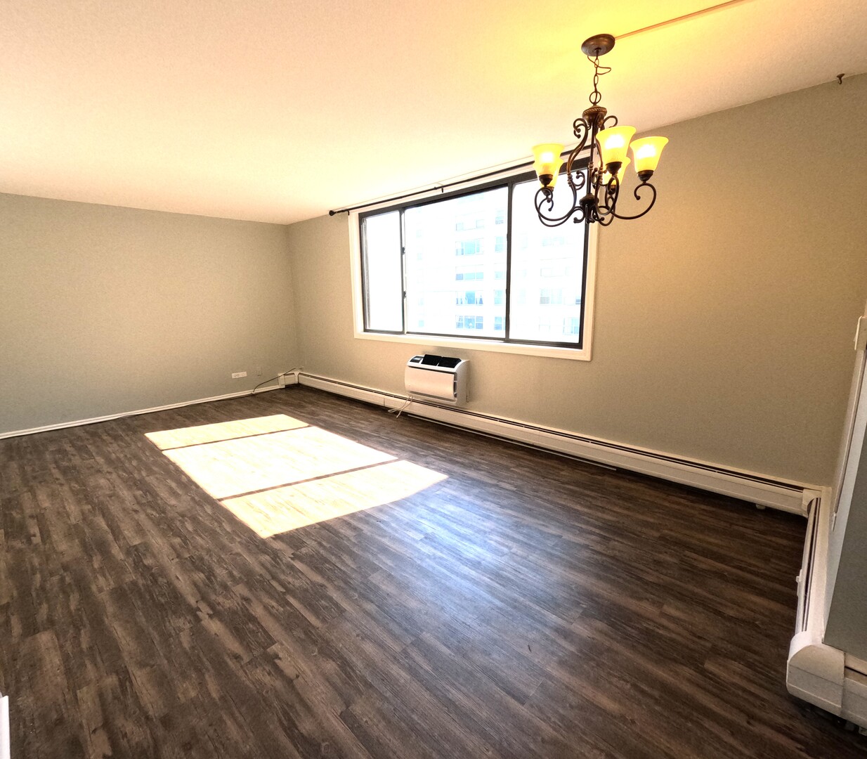 6325 North Sheridan Road, Unit 2003 Chicago, IL 60660 - Photo 3 of 17 wooden floor in an empty room with a window