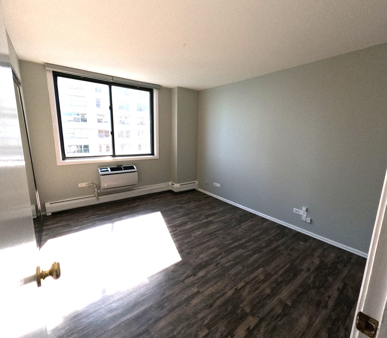 6325 North Sheridan Road, Unit 2003 Chicago, IL 60660 - Photo 5 of 17 wooden floor in an empty room with a window