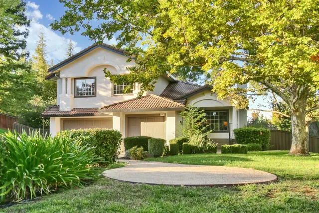a front view of a house with a yard and trees