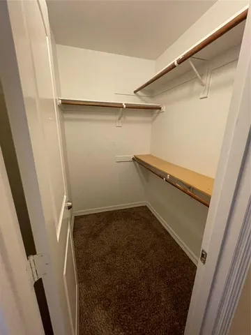 an empty room with a chandelier fan and a window