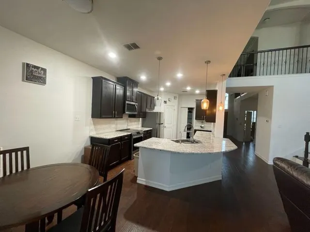 a kitchen with kitchen island a stove a table and chairs