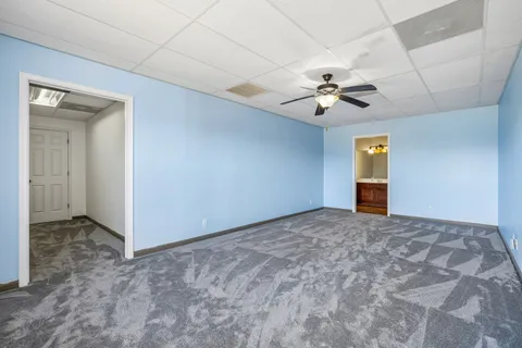 an empty room with windows and fan