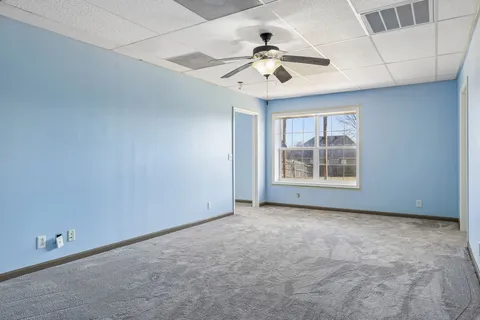 en empty room with ceiling fan and window