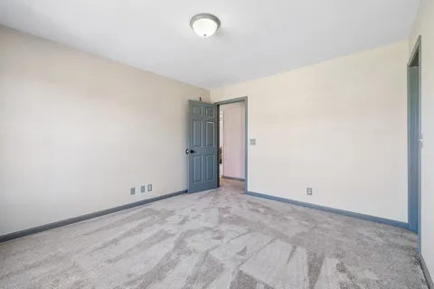 an empty room with windows and ceiling fan