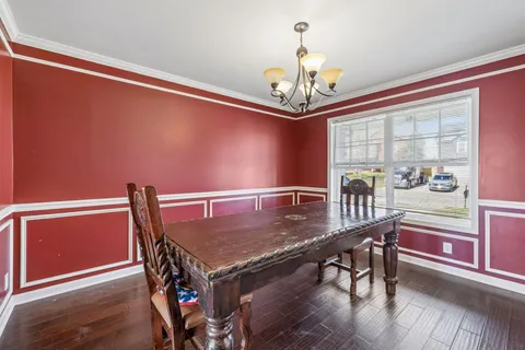 an empty room with wooden floor a fireplace a ceiling fan and windows