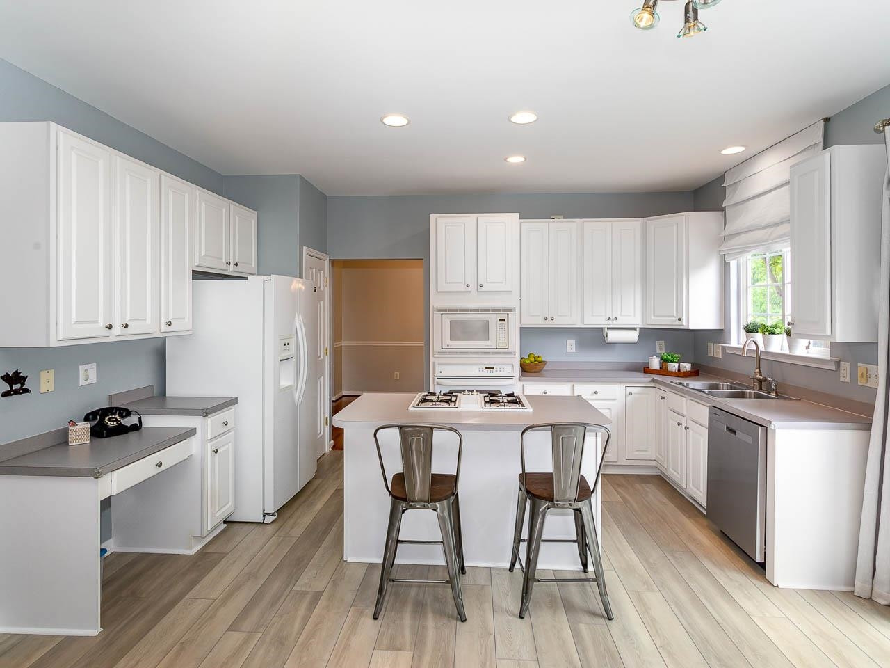 3702 Appling Way Durham, NC 27703 - Photo 6 of 34 a kitchen with a dining table chairs refrigerator and cabinets