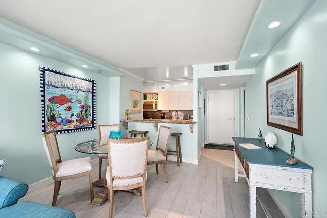 a kitchen with stainless steel appliances wooden floor and a refrigerator