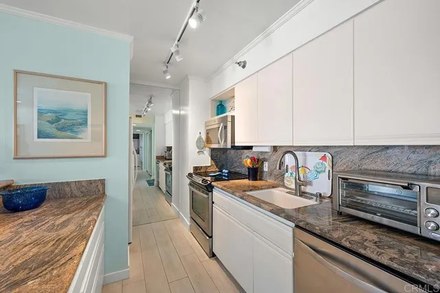 a living room with stainless steel appliances granite countertop furniture and a kitchen view