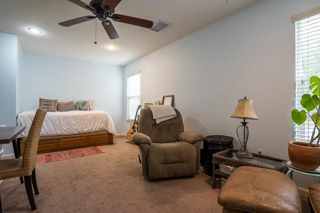 a bedroom with bed and a chandelier fan