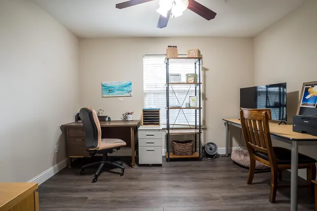 a view of a workspace with furniture and a window