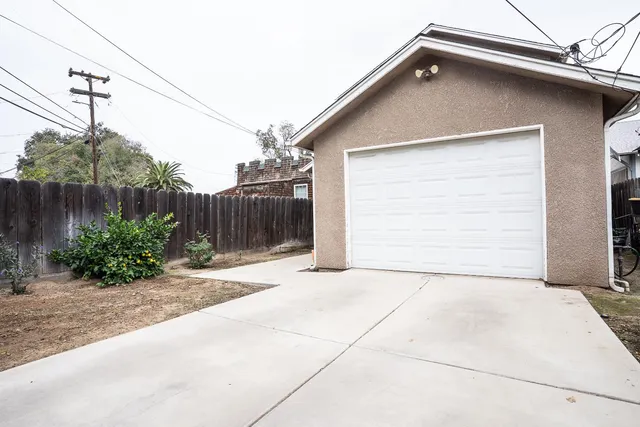a backyard of a house with potted plants and couches