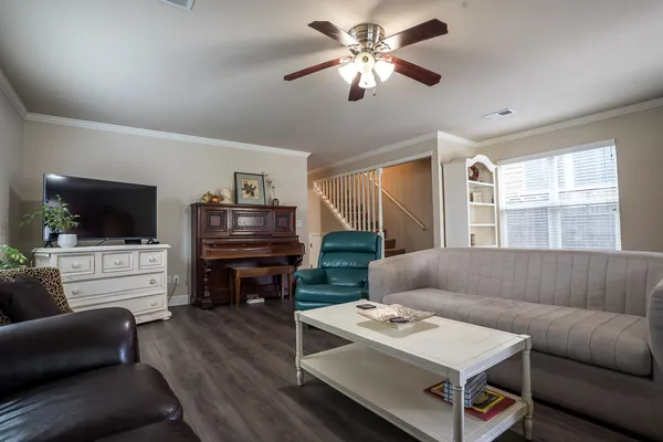 a living room with furniture ceiling fan and a window