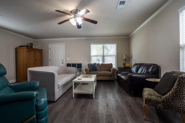 a living room with furniture ceiling fan and a window