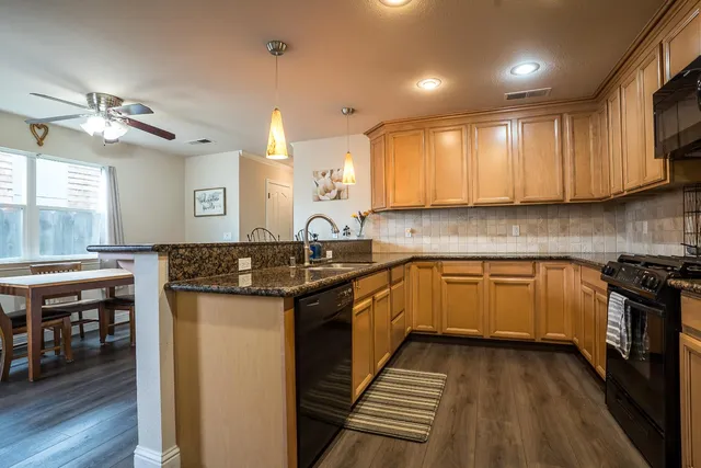a kitchen with kitchen island granite countertop wooden cabinets and a stove