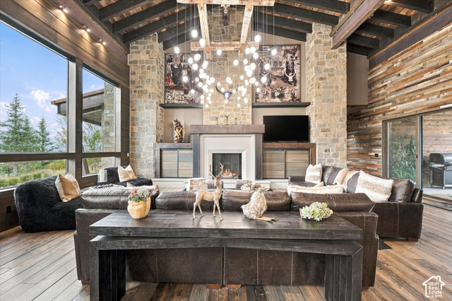 5936 Triple Crown Trail Oakley, UT 84055 - Photo 10 of 57 Stone fireplace with a mantel, exposed wood ceiling beams, wood-finish flooring, and expansive windows
