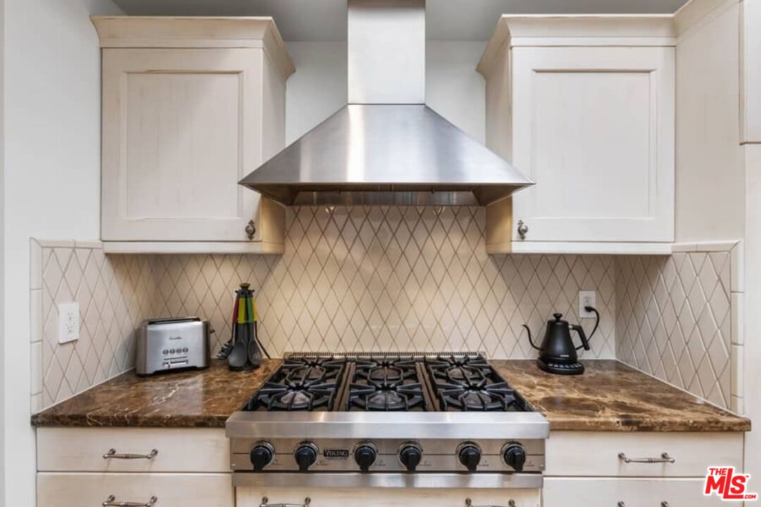 261 South Reeves Drive Beverly Hills, CA 90212 - Photo 11 of 43 a kitchen with granite countertop a stove and a sink