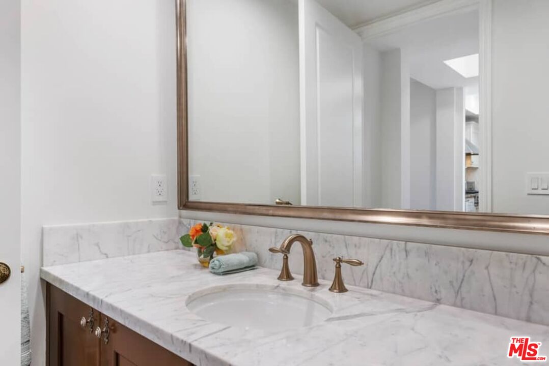 261 South Reeves Drive Beverly Hills, CA 90212 - Photo 15 of 43 a bathroom with a sink and a mirror