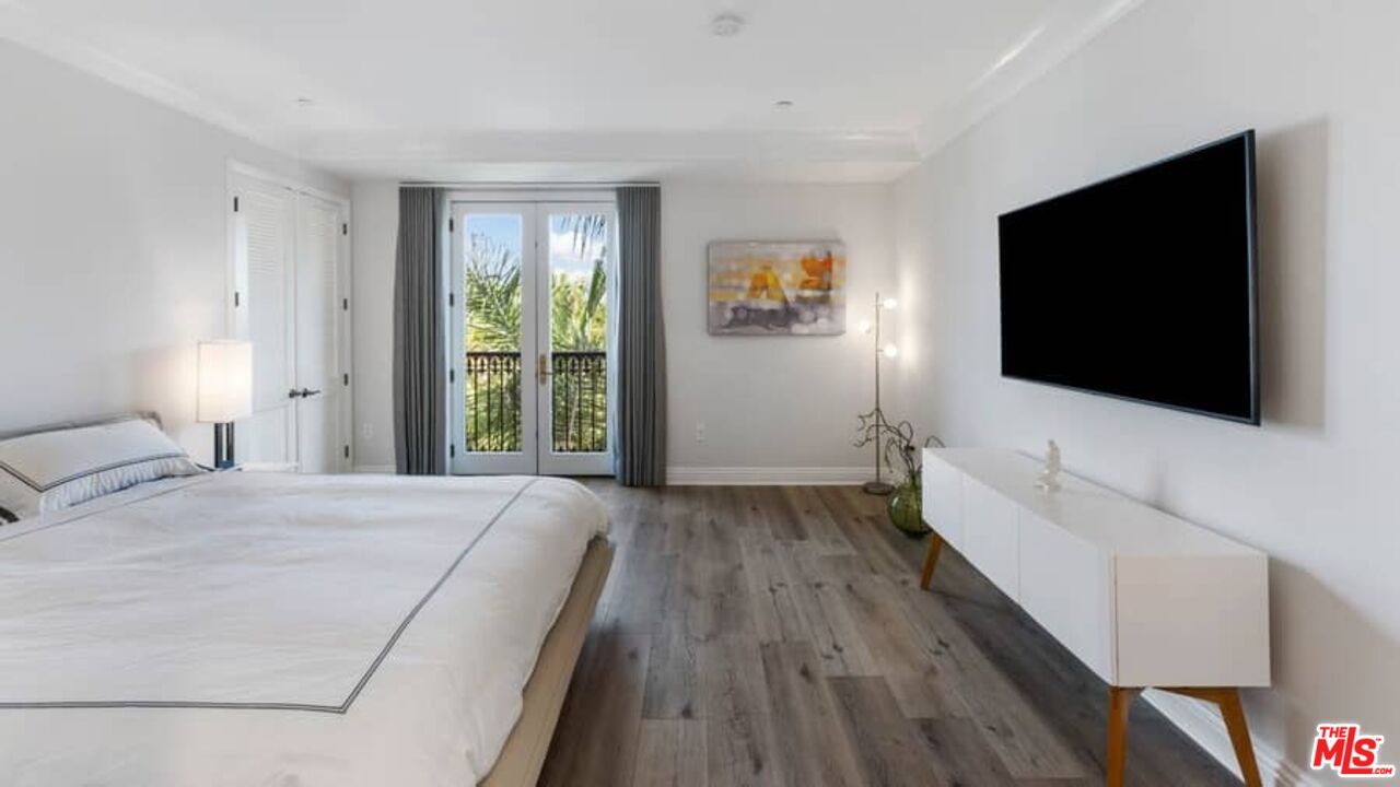 261 South Reeves Drive Beverly Hills, CA 90212 - Photo 17 of 43 a bedroom with a bed and a flat screen tv