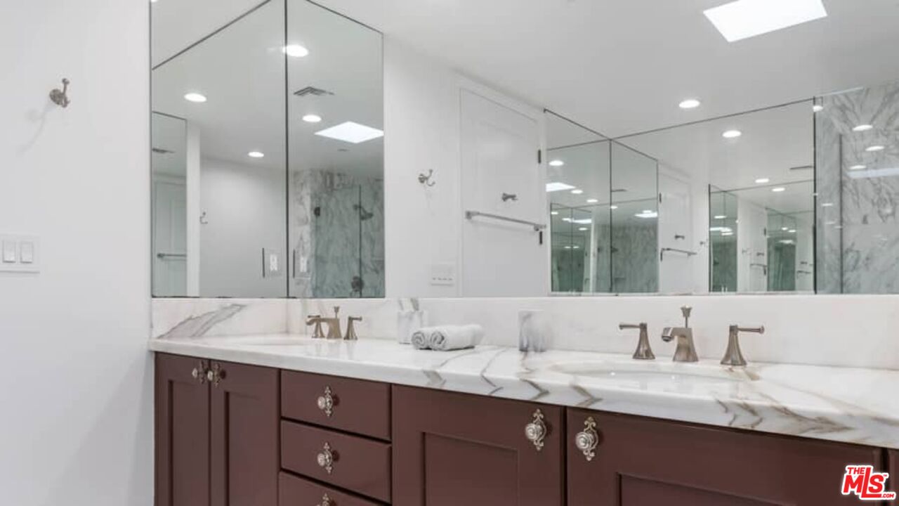 261 South Reeves Drive Beverly Hills, CA 90212 - Photo 21 of 43 a bathroom with a granite countertop sink double and mirror