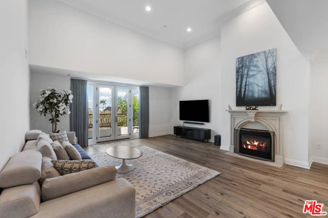 261 South Reeves Drive Beverly Hills, CA 90212 - Photo 5 of 43 a living room with furniture a flat screen tv and a fireplace
