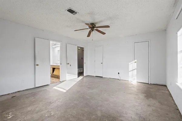 a view of a room with chandelier fan and windows