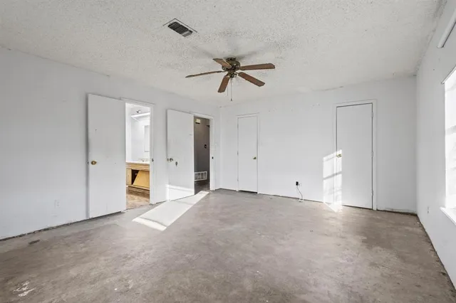 a view of a room with chandelier fan and windows